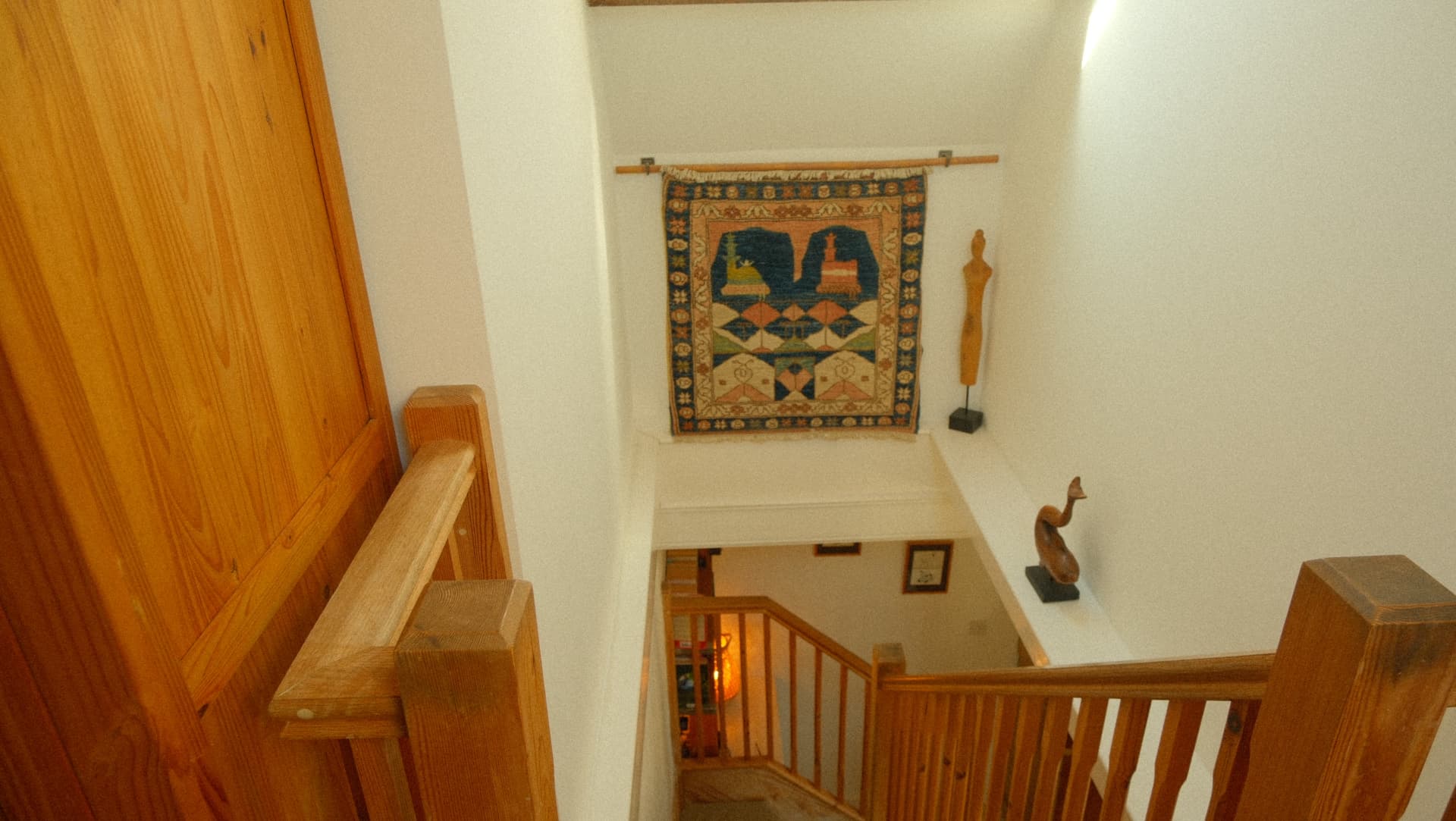 Down the stairs, past the wall hanging